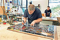Mitarbeiter von Derix fertigen in der Werkstatt farbige Fenster an. Fotos: Andrea Enderlein/epd