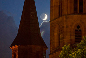 Blick auf den zunehmenden Mond zwischen den Türmen der Kaiserslauterer Stiftskirche. Foto: view