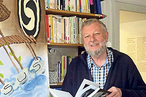 In seinem Büro in Rockenhausen mit einem Plakat des Arbeitskreises Papua: Der 65-jährige Ruprecht Beuter. Foto: Jung
