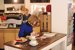 Ungewöhnlicher Beruf: Sabine Rieker lebt vom Postkartenschreiben. Ihr Arbeitsort ist ein Stuttgarter Café. Foto: Werner Kuhnle