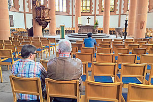 Besucher sitzen in der evangelischen Heiliggeistkirche in Heidelberg. Foto: epd