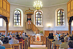 Während der Festpredigt in der Kirche in Miesau: Christian Schad auf der Kanzel zwischen den neuen Schreiter-Kunstfenstern im Altarraum. Foto: view