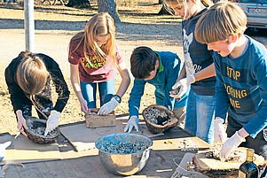 Füllen Baumrindenteile mit selbst gefertigtem Vogelfutter: Kinder im CVJM-Haus der Nachhaltigkeit in Otterberg. Foto: pv