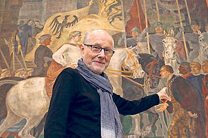 Gegen das Vergessen: Manfred Peters vor dem Kessler-Fresko im Hohenstaufensaal, auf dem sein Vater abgebildet ist. Foto: VAN
