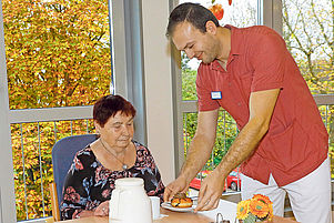Ist beim Diakoniewerk Zoar in der Ausbildung zum Altenpfleger: Dorian Topi mit einer Heimbewohnerin. Foto: J. Hoffmann