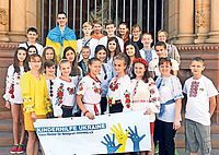 Auf den Domtreppen: Für den Ausflug nach Speyer haben die Jugendlichen aus der Ukraine ihre Trachten angezogen. Foto: Landry