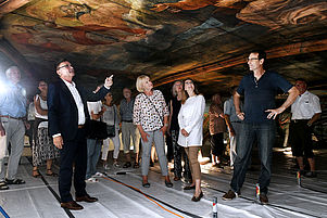 Auf dem Gerüst aus nächster Nähe: Bauvereinsvorsitzender Henri Franck führt die Besucher unter die Deckengemälde. Foto: Landry