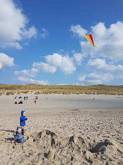 Matilda übte Drachen steigen lassen im Urlaub am Strand.