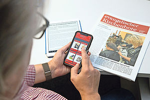 Der KIRCHENBOTE in dreifacher Ausfertigung: Ein einzelner Artikel auf dem Tablet, die Titelblätter auf dem Smartphone und als gedruckte Ausgabe. Foto: Mendling